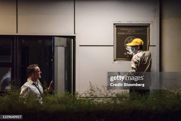 Bloomberg Best of the Year 2020: Jim Mullinax, U.S. Consul General in Chengdu, left, speaks with a worker trying to remove the official plaque from...