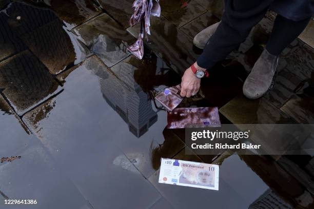 Extinction Rebellion Climate Change activists dressed in City suits, vomit 'oil' outside the Baltic Exchange, home to the International Chamber of...