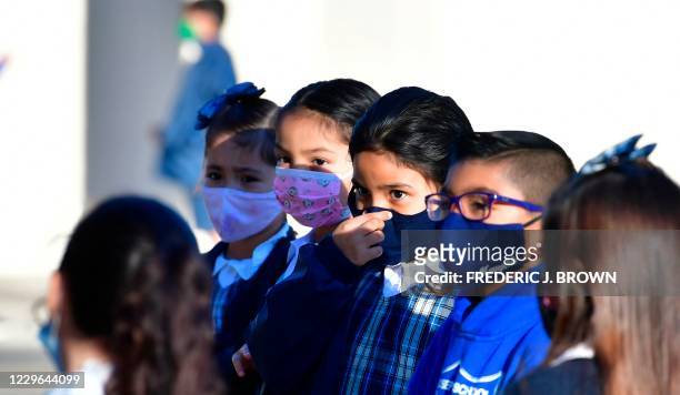 Students adjusts her facemask at St. Joseph Catholic School in La Puente, California on November 16 where pre-kindergarten to Second Grade students...