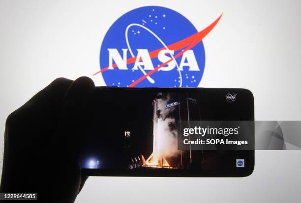 In this photo illustration a screenshot of the webcast of NASA SpaceX Crew-1 mission launch is seen on a smartphone screen. NASA and SpaceX launched...