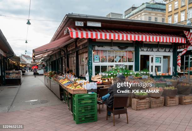 Fruits and vegetables vendor waits for customers at the deserted Naschmarkt market in Vienna, Austria, on November 17, 2020. - Austria has entered...