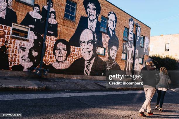 Pedestrians pass in front of a mural outside the National Civil Rights Museum at the Lorraine Motel in downtown Memphis, Tennessee, U.S., on Sunday,...