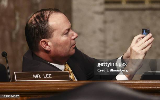 Senator Mike Lee, a Republican from Utah, photographs a display with a mobile device during a Senate Judiciary Committee hearing in Washington, D.C.,...