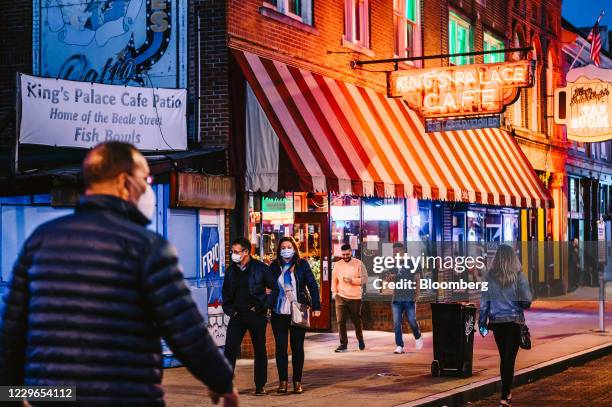 Pedestrians wearing protective masks walk along Beale Street at night in Memphis, Tennessee, U.S., on Sunday, Nov. 15, 2020. As coronavirus cases...