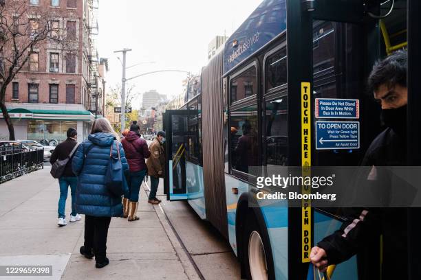 Commuters exit and board a bus in New York, U.S., on Tuesday, Nov. 17, 2020. New York's Metropolitan Transportation Authority needs $12 billion of...