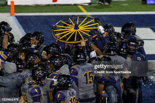 Kent State Golden Flashes players celebrate as they hoist the Wagon Wheel trophy following the college football rilvalry game between the Akron Zips...