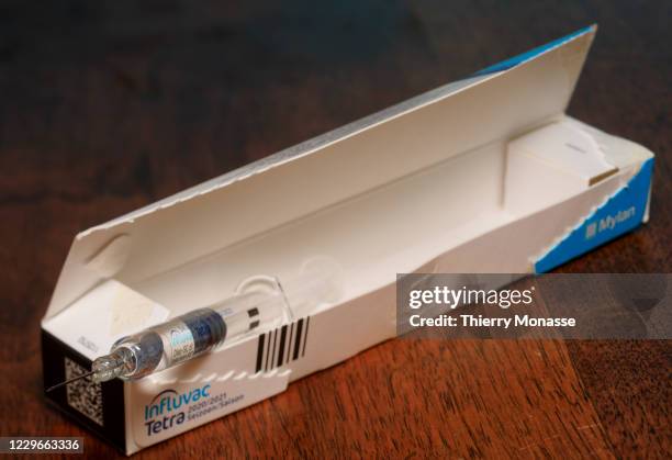 In this photo illustration - A flu vaccine syringe rests on a table on November 18, 2020 in Brussels, Belgium. The seasonal flu vaccine is made up of...