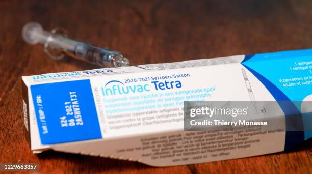 In this photo illustration - A flu vaccine syringe rests on a table on November 18, 2020 in Brussels, Belgium. The seasonal flu vaccine is made up of...