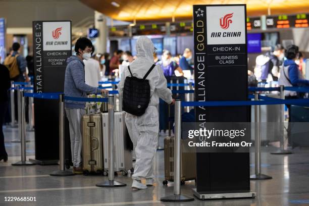 During the global coronavirus passangers wearing personal protective equipment check in at the Air China counter in Tom Bradley international at LAX...