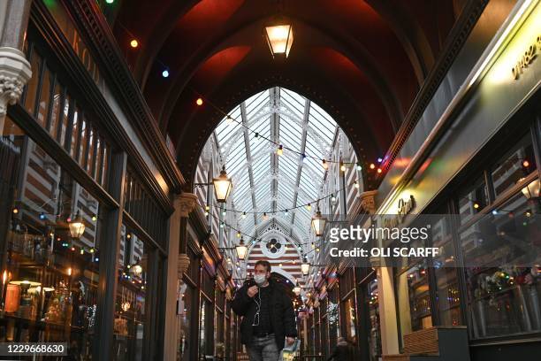 Man wearing a protective face covering to combat the spread of the coronavirus, walks through a shopping arcade in Hull, in north-east England on...