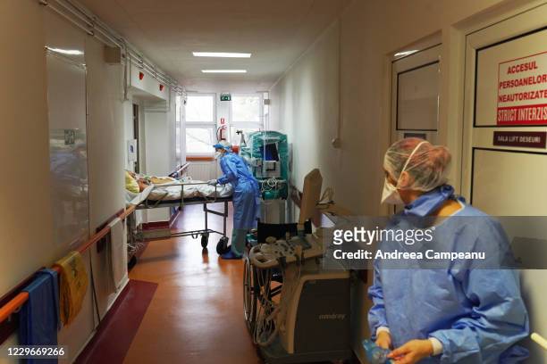 Intensive care medical staff, protected by PPE, Transport a patient infected with Covid-19 for testing, at the ICU at The Hospital for Infectious...