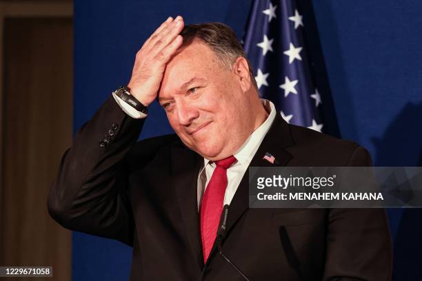 Secretary of State Mike Pompeo pats his head during a press conference with the Israeli Prime Minister and Bahrain's Foreign Minister after their...