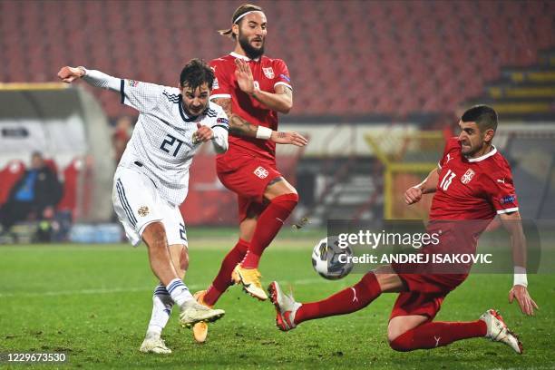 Russia's midfielder Aleksandr Erokhin shoots the ball past Serbia's midfielder Nemanja Gudelj and forward Stefan Mitrovic during the UEFA Nations...
