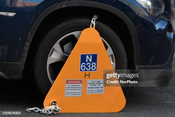 Car locked with a yellow clamped wheel lock by traffic authorities in Dublin's city centre.On Wednesday, November 18 in Dublin, Ireland.