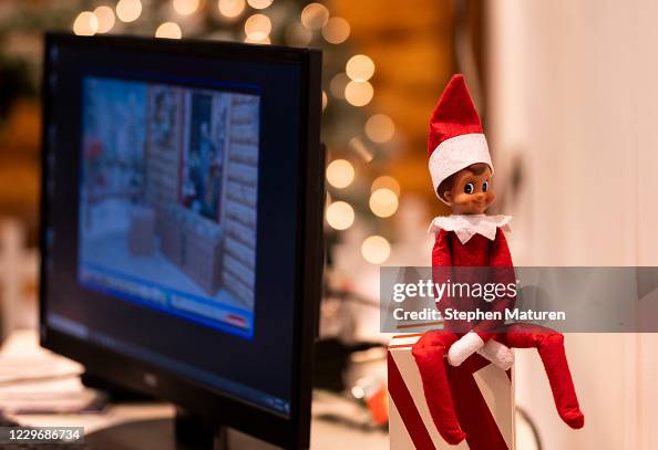 Elf Computer Screen A Christmas elf decoration sits next to a computer monitor is seen ...