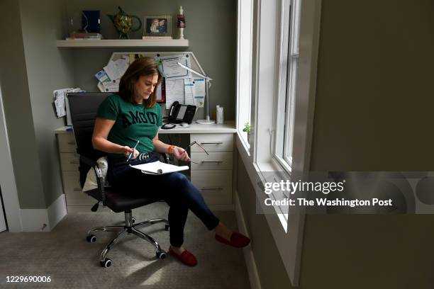 Sue-Ann Siegel goes over notes after taking a call from a man experiencing anxiety about the coronavirus as she monitors the Montgomery County...