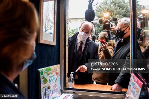 French Prime Minister Jean Castex speaks to merchants next to President of the National Assembly Richard Ferrand during a visit to Crozon, western...