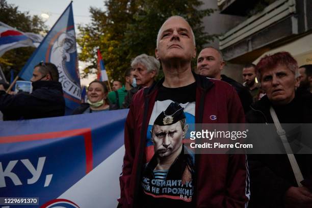 Serbian nationalist wears a t-shirt depicting Russian president Vladimir Putin as Serbian nationalists shout anti-Kosovo slogans, light flares and...