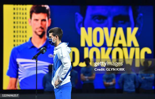 Serbia's Novak Djokovic wearing a protective face covering to combat the spread of the coronavirus, gives an on court interview after his straight...