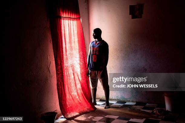 Saliou Diouf, a fisherman, poses for a portrait in his familys house in Mbour on November 17 after he tried to illegally cross to the Canary Islands...