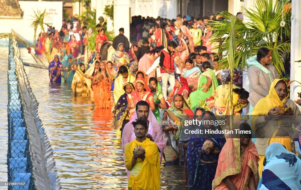 Chhatt Hindu devotees perform Chhath Puja rituals while standing in a water ...