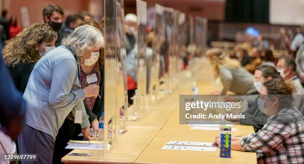 Representatives for President Donald Trump, left, looks over a ballots during the presidential recount vote for Dane County on November 20, 2020 in...