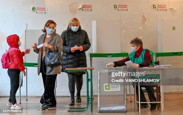 Women vote at a polling station as part of Georgia's parliamentary runoff elections in Tbilisi on November 21 amid the Covid-19 outbreak caused by...