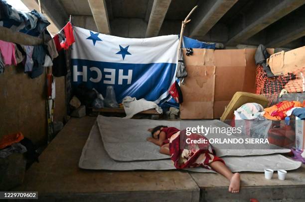 Girl sleeps under a bridge following the passage of Hurricane Iota in San Pedro Sula, 180 km north of Tegucigalpa, on November 21, 2020. - Hurricane...