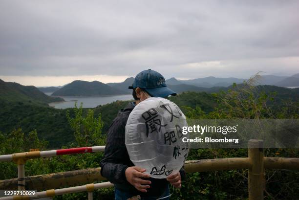 Family member of one of 12 Hong Kong people detained in mainland China prepares to release a balloon, marked with the name of one of the detainees,...