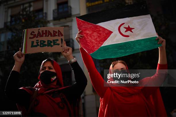 Women wearing face mask, carrying a Saharan flag and a placard that says Free Sahara and dressed in Malahfas during a demonstration to demand the end...