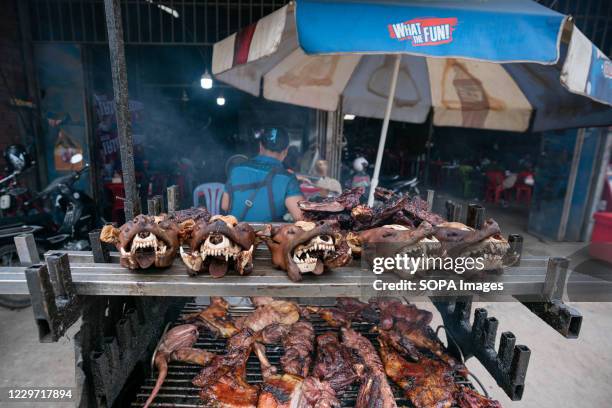 Dog meat is seen displayed on a grill for sale at a restaurant. An estimated 800 people a year die of rabies in Cambodia, one of the highest deaths...