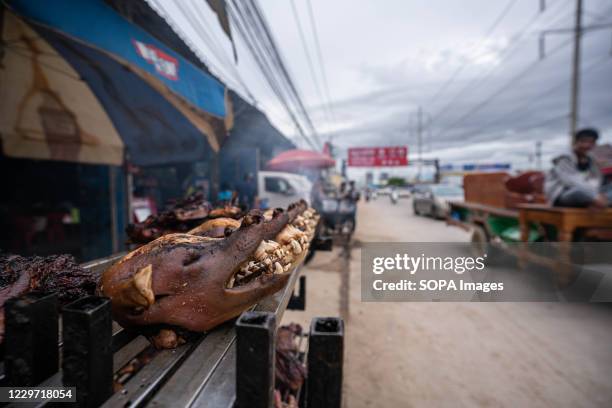 Dog meat is seen displayed on a grill for sale at a restaurant. An estimated 800 people a year die of rabies in Cambodia, one of the highest deaths...