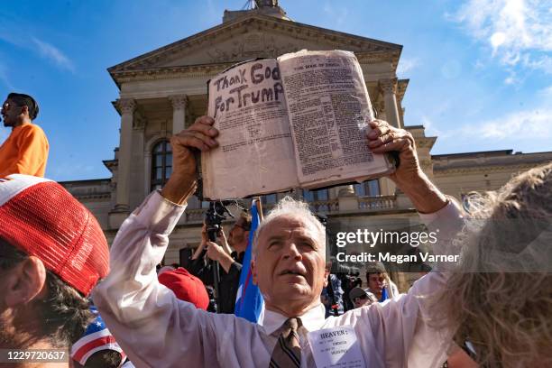 Preacher holds up his Bible while supporters of Donald Trump host a 'Stop the Steal' protest outside of the Georgia State Capital building on...