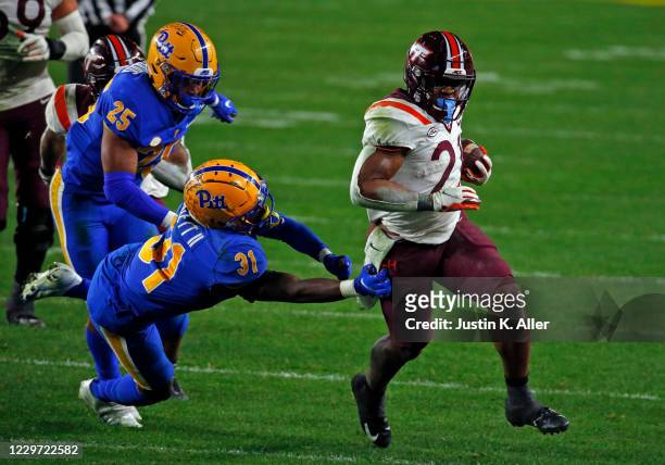 Khalil Herbert of the Virginia Tech Hokies rushes against Erick Hallett of the Pittsburgh Panthers at Heinz Field on November 21, 2020 in Pittsburgh,...