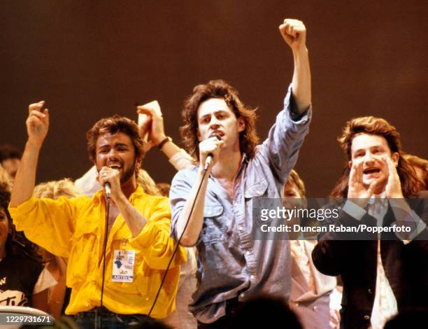 Singers George Michael, Bob Geldof and Bono performing the Band Aid single "Do They Know It's Christmas" during the finale of the Live Aid concert at...
