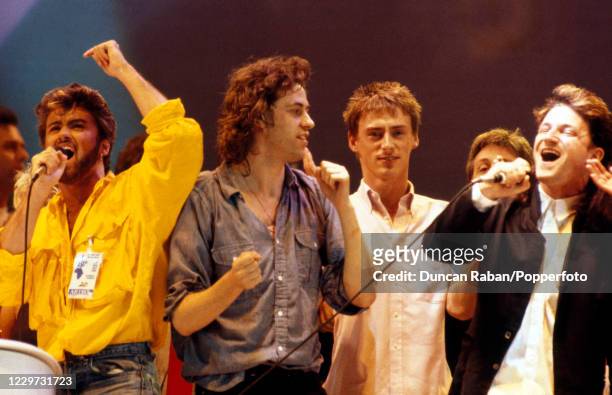 Singers George Michael, Bob Geldof, Paul Weller and Bono performing the Band Aid single "Do They Know It's Christmas" during the finale of the Live...