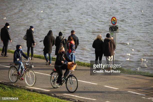 People are strolling and cycling on Vistula Boulevards during coronavirus pandemic. Krakow, Poland on November 22, 2020. Tougher measures to battle...