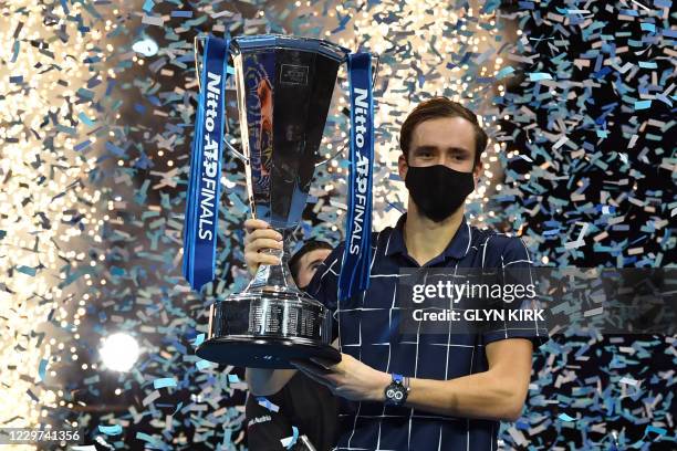 Russia's Daniil Medvedev wearing a protective face covering to combat the spread of the coronavirus, poses with the winner's trophy after his 4-6,...