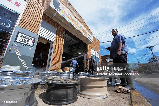 Alberto Taveras cleans wheels at J&J Tires and Wheels where rains and the cresting of nearby waters flooded the shop on August 29, 2011 in Lodi, New...