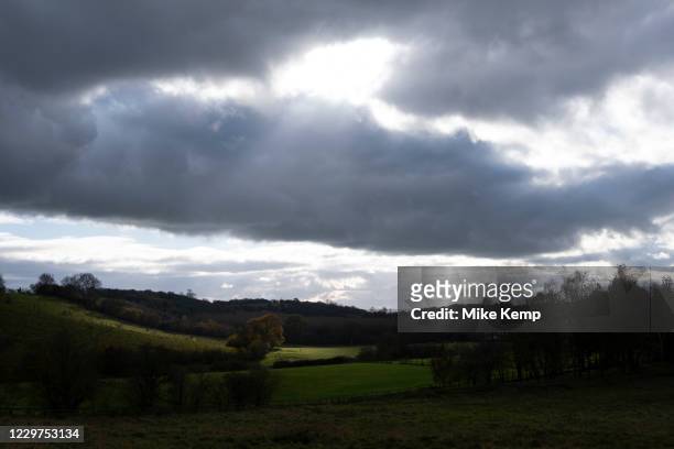 Warwickshire landscape on 10th November 2020 near Henley-in-Arden, United Kingdom. A shaft of light through clpouds lights up a grazing field below.
