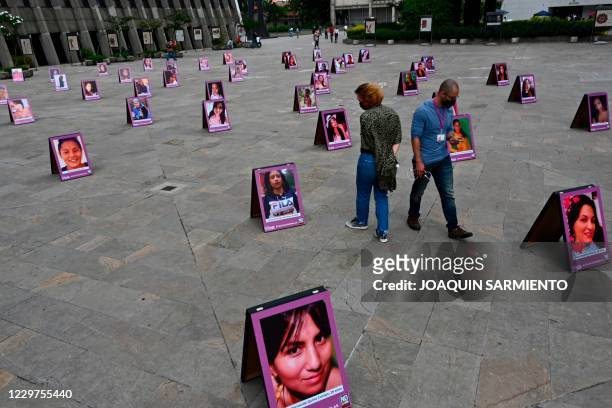Man and a woman look at photos of vicitms of femicide displayed as part of an awareness campaing in the framework of the International Day for the...