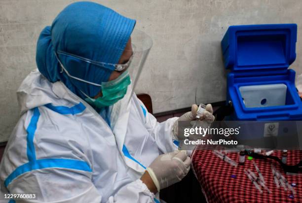 Health workers prepare to inject tetanus diphtheria vaccine to students during the School Child Immunization Month at SDN Panaragan 1, Bogor, West...