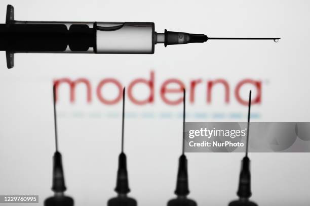 Medical syringes are seen with Moderna logo displayed on a screen in the background in this illustration photo taken in Poland on November 23, 2020.