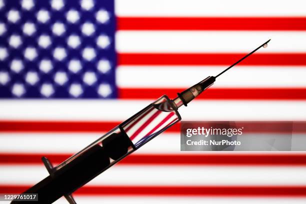 Medical syringe is seen with American flag in the background in this illustration photo taken in Poland on November 23, 2020.