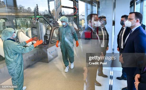 German Health Minister Jens Spahn looks at the vaccine bottling plant as he tours the lab facilities of vaccine maker IDT Biologika accompanied by...