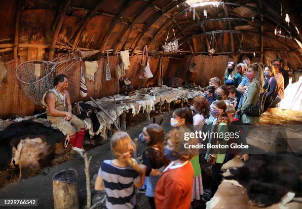 Tim Turner, a Cherokee Indian and museum educator, sits inside a nush weetu at the Hobbamock Homesite as a group of children listen to him explain...