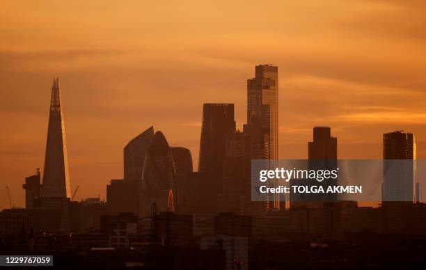 The skyscrapers and office buildings in the City of London, including The Shard , are bathed in yellow light during the autumn sunset on November 24,...
