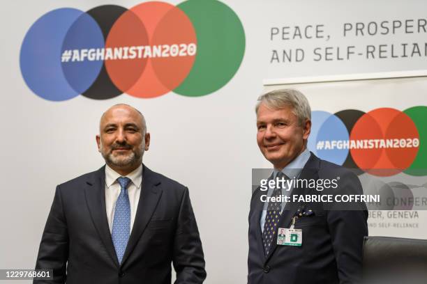 Afghanistan's Foreign Minister Mohammad Hanif Atmar smiles next to Finland's Foreign Minister Pekka Haavisto after a press conference closing the...
