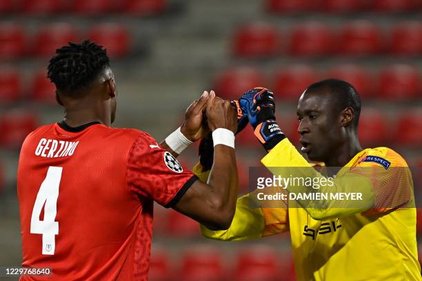 Rennes' French defender Gerzino Nyamsi and Rennes' Senegalese goalkeeper Alfred Gomis shake hands during the UEFA Champions League Group E football...