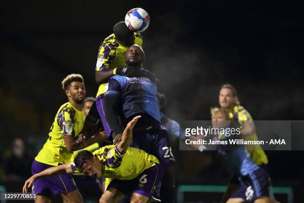 Adebayo Akinfenwa of Wycombe Wanderers battles for a header with Naby Sarr and Jonathan Hogg of Huddersfield Town during the Sky Bet Championship...